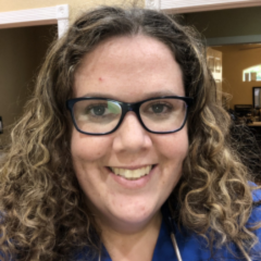 Close up photo of woman wearing glasses with curly hair