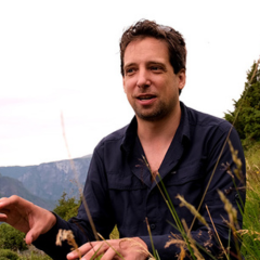 Man with mountains in the background and plants in foreground