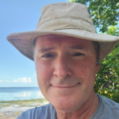 Close up picture of a man wearing a sun hat. 