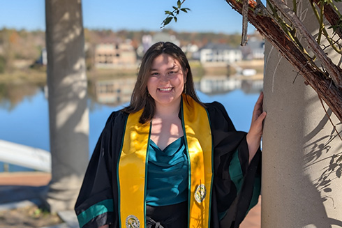 Reni Poston-Hymel wearing a cap and gown for her graduation photo