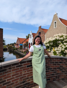 Student posing on brick bridge over canal.