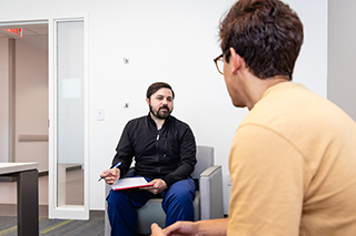 Two people sitting in chairs talking