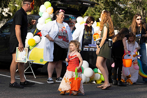 little girl in halloween costume with adults around