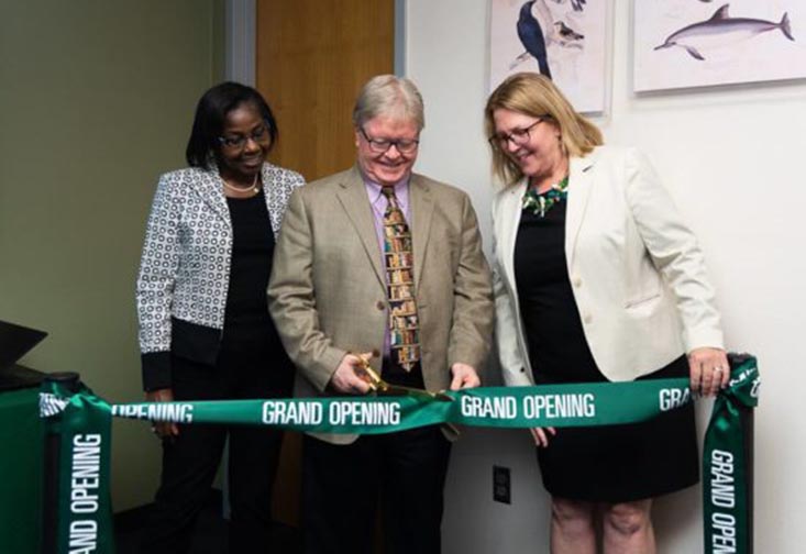 Interim Regional Vice Chancellor of Academic Affairs Olufunke Fontenot, Interim Regional Chancellor Martin Tadlock and Dean of the Nelson Poynter Memorial Library Catherine Cardwell cutting a ribbon at the grand opening