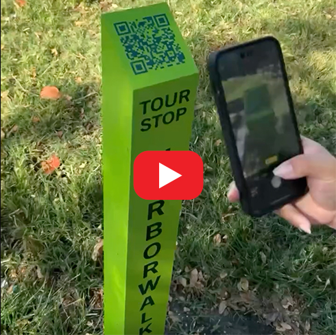 phone scanning QR code on top of tour post