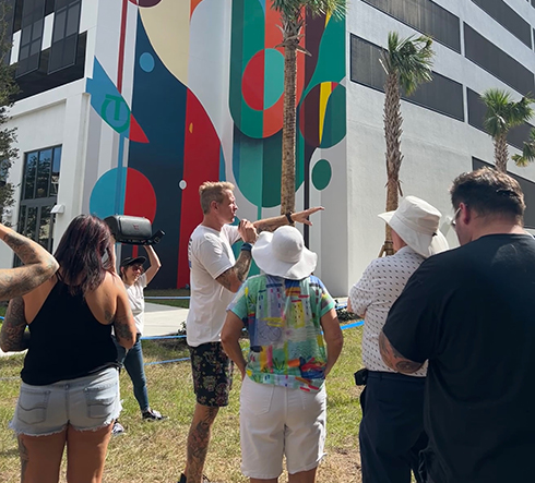 tour group in front of a mural on a building